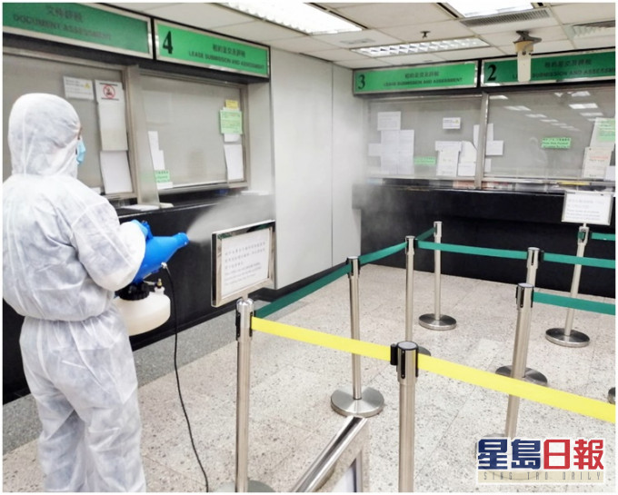 穿全套保护衣工作人员在大楼内消毒。网图