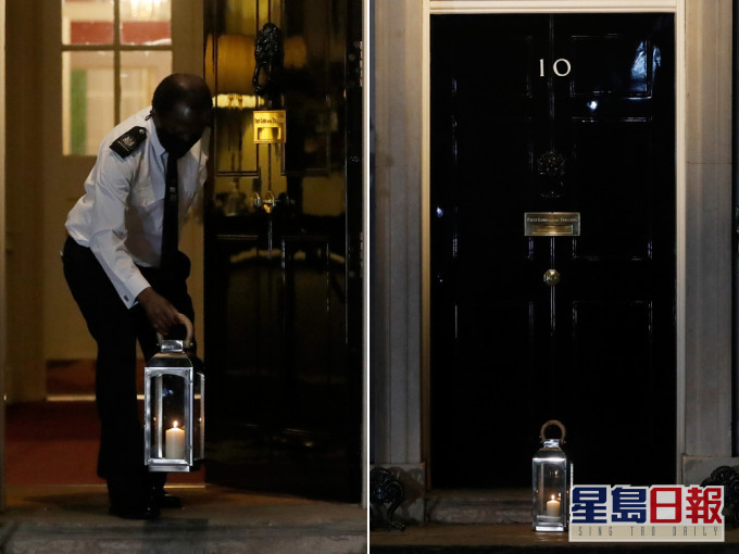 在唐宁街10号首相府，工作人员在门外放置蜡烛。AP图片