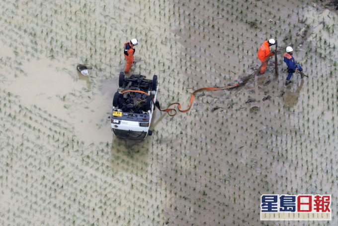 暴雨引致河流泛滥，汽车被冲到稻田。AP