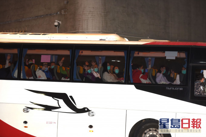 首批湖北返港人士完成隔離令,今晨乘旅巴離開駿洋邨,向車外人揮手。尹敬堂攝
