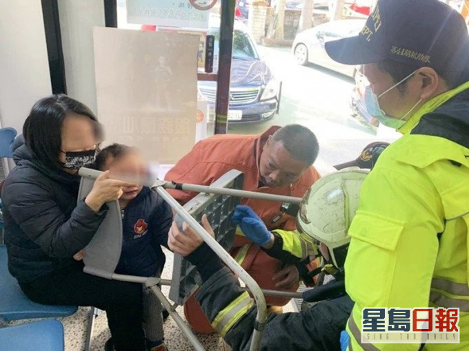 消防員用特殊工具切割塑膠椅，幫助男童脫困。網圖