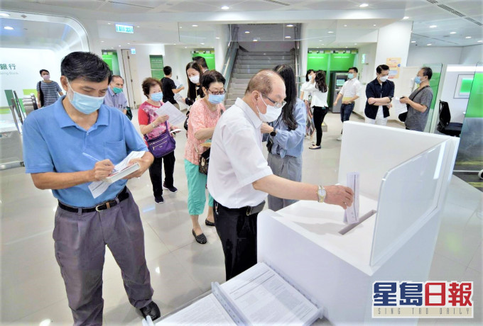 不少市民今早前往銀行排隊,親自交表。