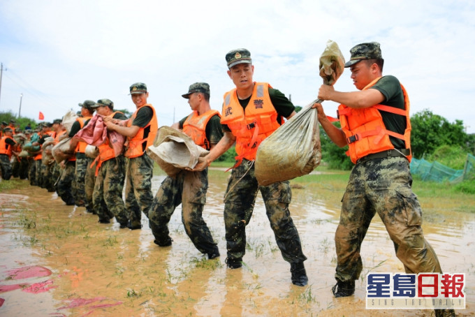 防洪堤决堤,武警运送沙包加固堤坝。AP图