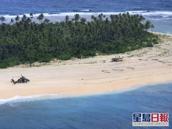 3名水手在無人島沙灘畫「SOS」求救。 AP