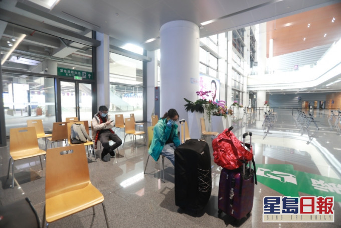 在珠海市港珠澳大橋珠海公路口岸,入境人士登記完旅客信息後,等待專車接送至隔離點。(新華社)