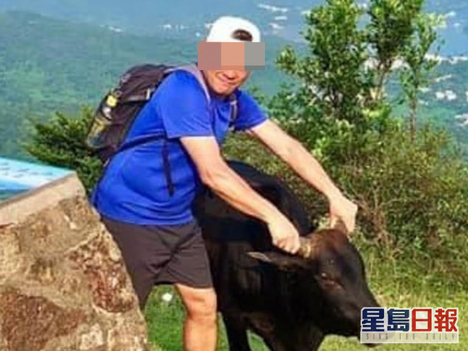 一名男子行山時,以雙手捉住兩隻牛角「打卡」拍照。「香港行山遠足之友(吹水山谷)」FB圖片