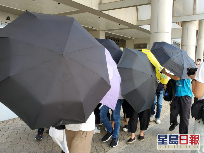 被告在遮陣掩護下離開。張旭珊攝