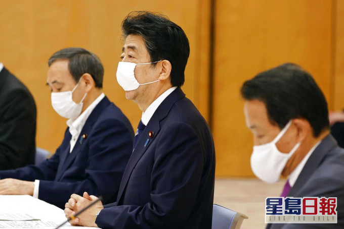 日本首相安倍晋三（中）。AP资料图片