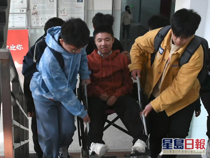 同学们接力10年护送渐冻症男孩上学。