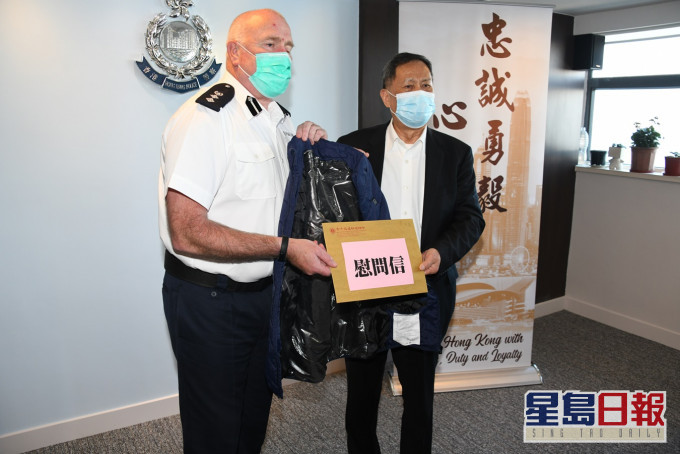 福建社团联会主席吴换炎(右)向东区警区指挥官韦志达送上背心羽绒服。