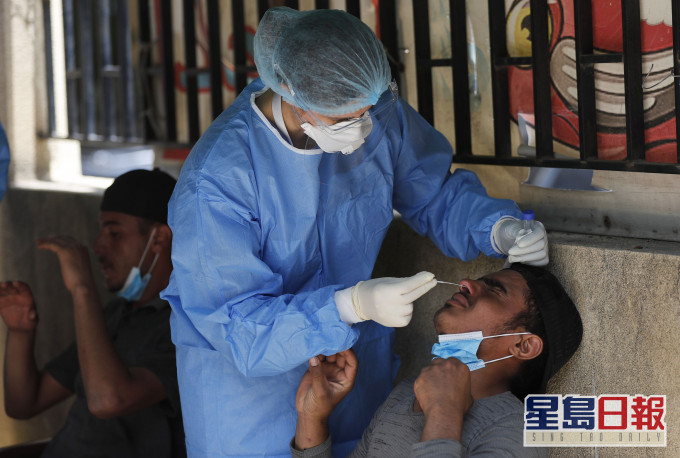 一名護士在孟加拉貝魯特對一名工人進行病毒檢測。 AP