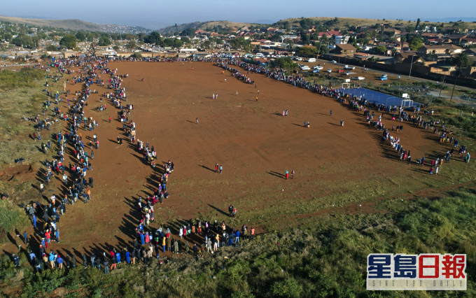 南非比勒陀利亞大批民眾在疫情下排隊等候領取食物援助。 AP圖