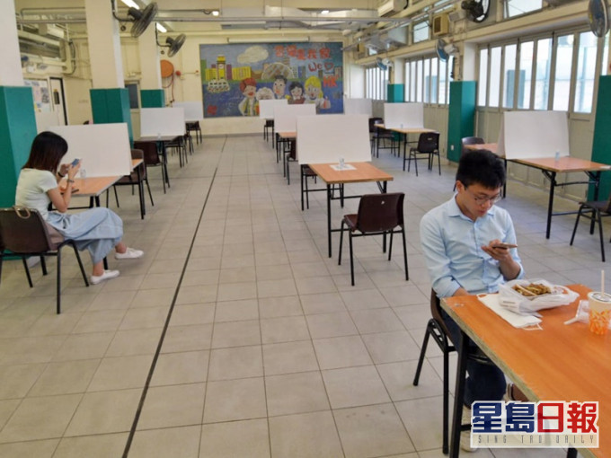 梁顯利油麻地社區中心放有18張長枱,每枱相隔1.5米,桌上有紙板分隔。