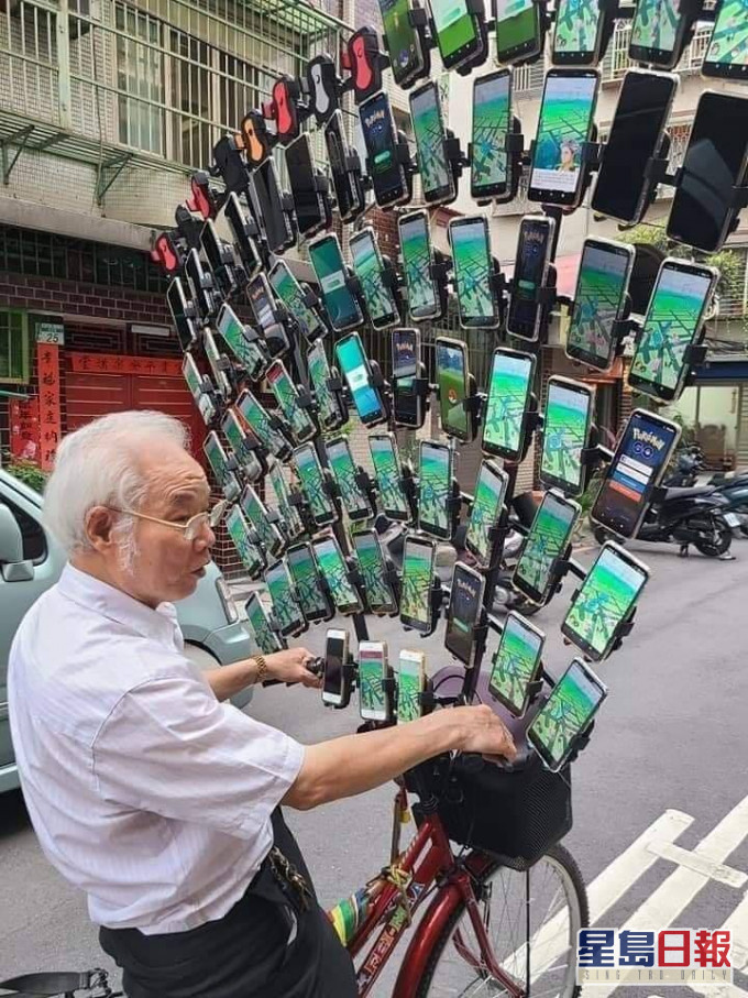 手機的排列高度超出老伯2個頭,完全遮蓋他的面部。FB專頁「爆料公社」圖片