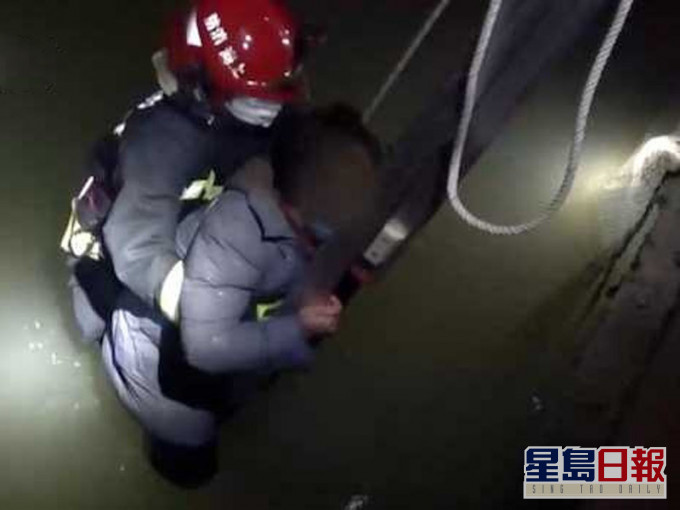 消防员一边安慰著刘女士，一边迅速用救援绳将她固定住，然后用力将她拉上云梯。（网图）