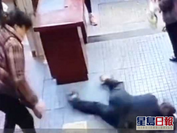 大妈被摔在地上。网图
