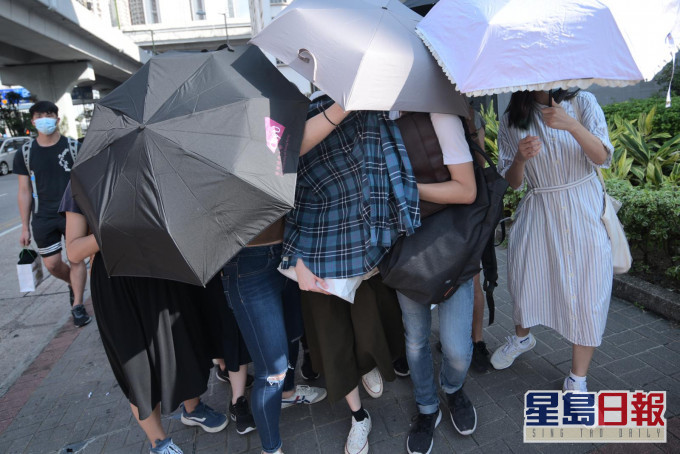 被告梁倩珩(藍衣遮蓋者)。