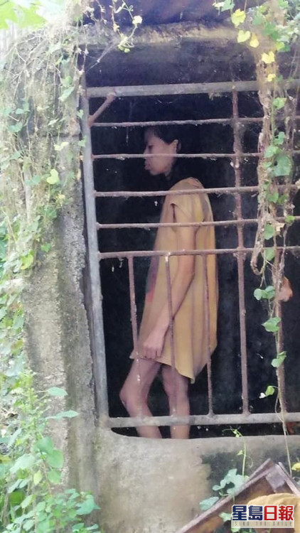 女子獨自一人在鐵籠內對著牆壁喃喃自語。（FB圖片）