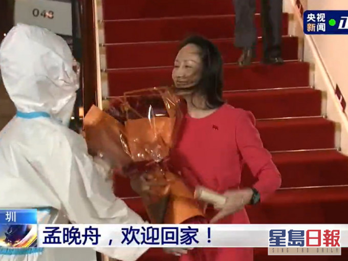 防疫人员向孟晚舟递上鲜花。央视影片截图