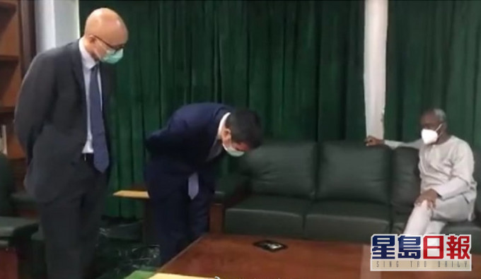 中國駐尼日利亞大使周平劍低頭看手機。網上圖片