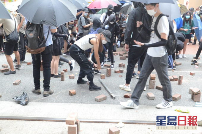 示威者掘起磚頭投擲到馬路。