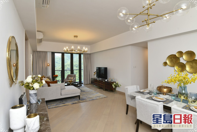 客廳擺放偌大曲尺形駝色沙發，打造舒適放鬆身心的空間。