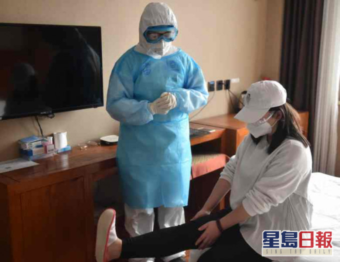 醫生正指導一名受觀察人員進行適當的室內運動。新華社