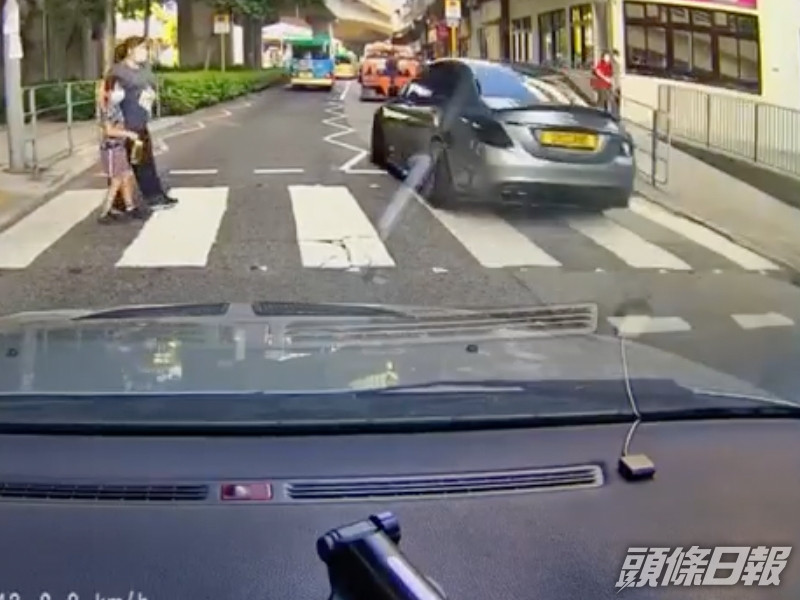 該對母女亦嚇得立即停下,等待私家車橫過後始續過馬路。 影片截圖
