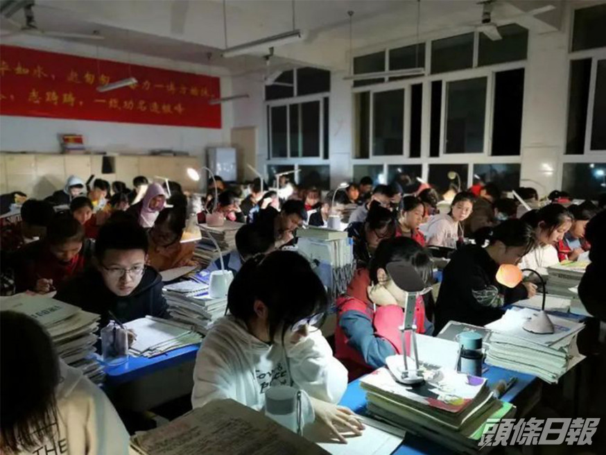 四川一所中學學生停電下自備枱燈繼續溫習。網圖