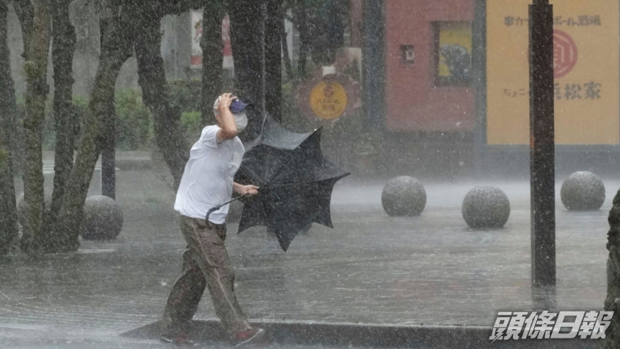 靜岡縣一名男子在大風大雨中前行。AP