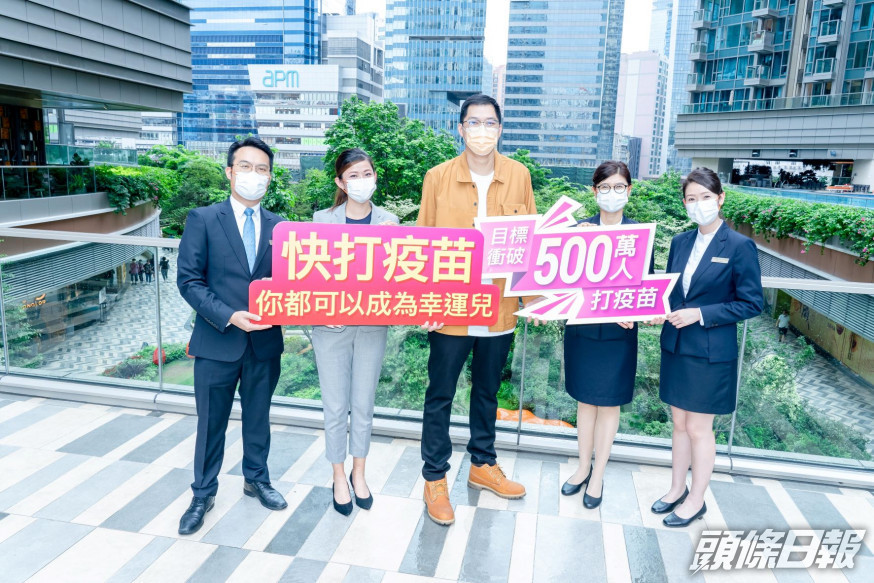 第一輪抽獎終極大獎得主李先生(中),鼓勵香港市民接種疫苗,為將來生活回復常態、
再次出國旅行作好準備。