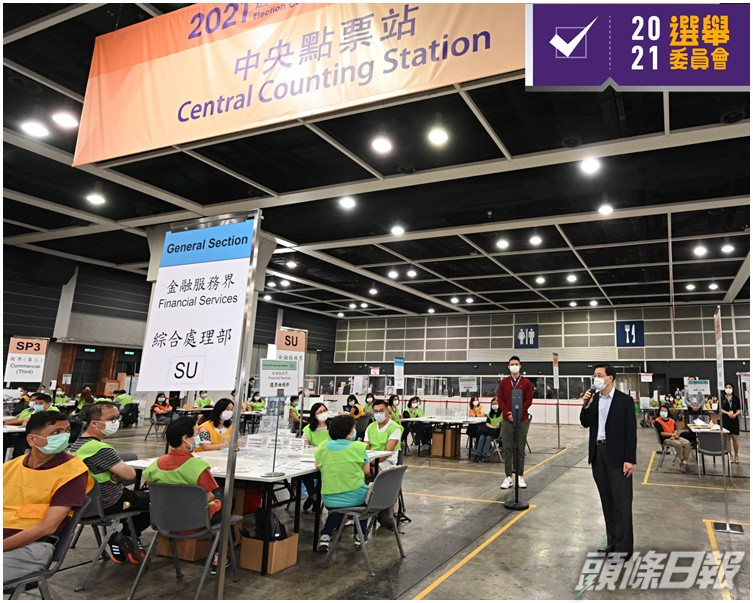 李家超(右)到會展的中央點票站和投票站,視察投票和點票的準備及安排。
