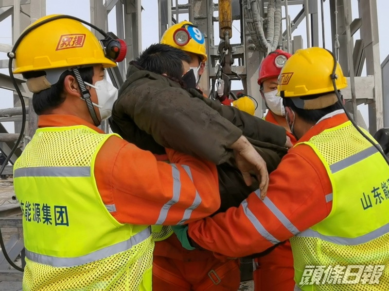 首名獲救礦工雙眼蒙上黑布送院。新華社