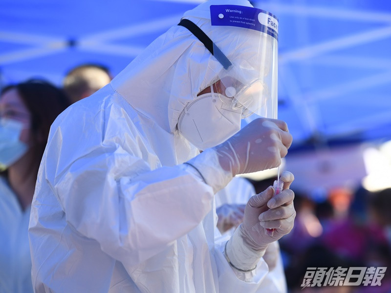 在南京市醫生張勇正為居民進行核酸檢測取樣。新華社
