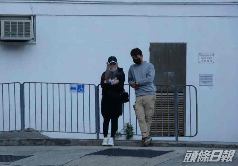 兩名男女親友倚在欄杆前神情黯然。