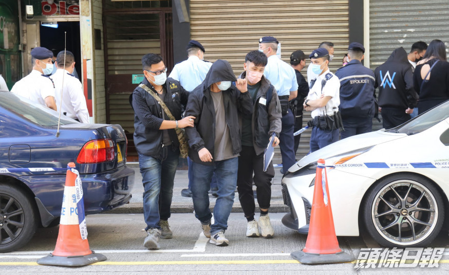 警方在酒吧帶走一名男子。
