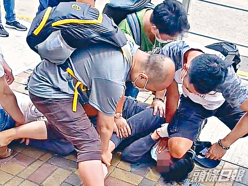 多名途人合力制服其中一疑匪按地上。