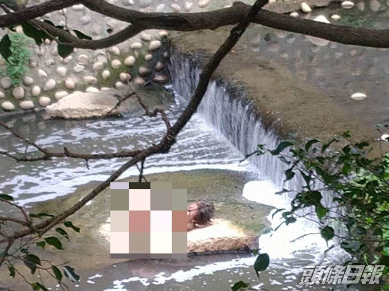 男子一絲不掛躺在排水溝的大石上。中時