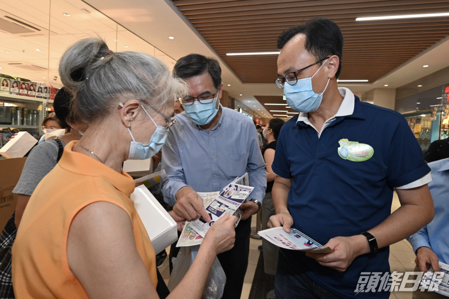 聶德權(右一)到石籬商場派發宣傳單張。 政府圖片