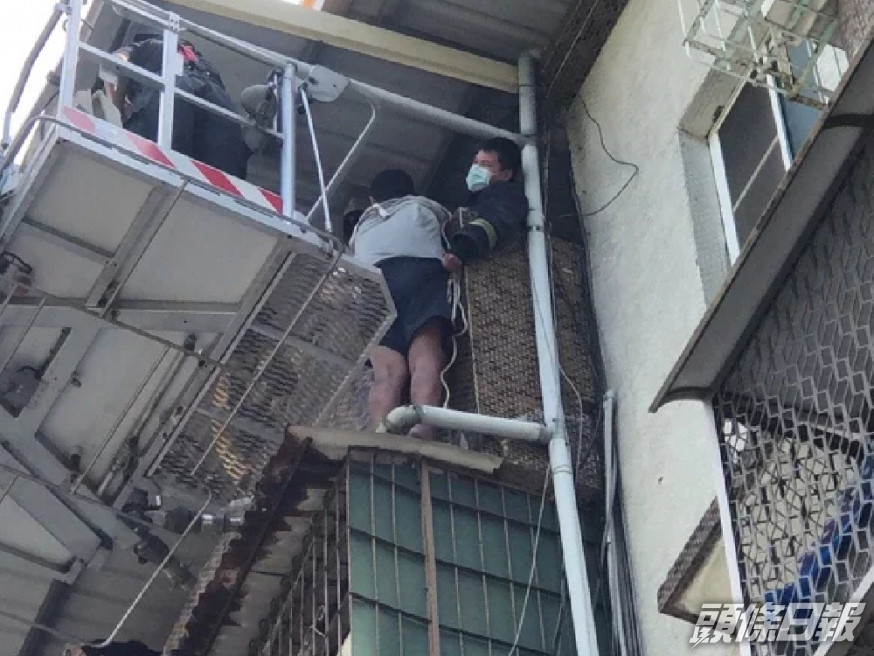高雄男子危站在屋簷上,最後要由消防員架起雲梯去拯救。(網上圖片)