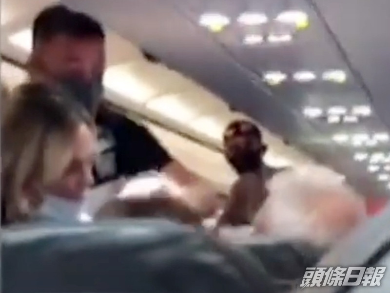 男子被摑後惱羞成怒,欲報復妻子,幸附近乘客見狀立即站起身阻止。影片截圖