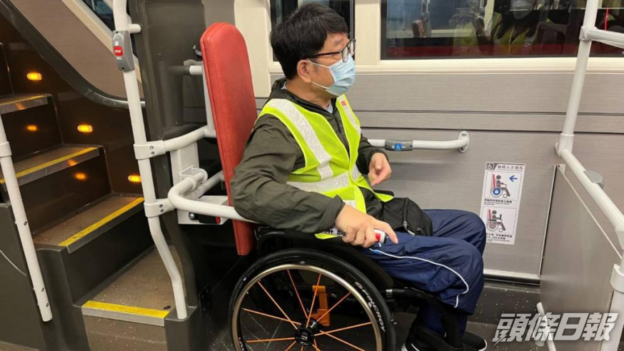 香港復康力量董事伍強試用新的扶手，認為新設施可以保護輪椅乘客。九巴圖片