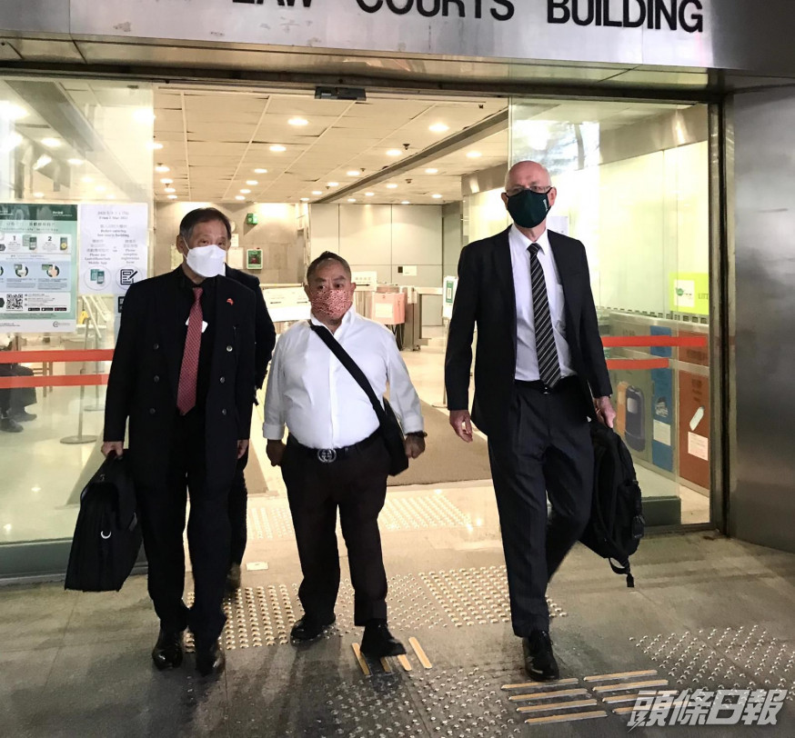 被告胡炳雄(中)、代表大律師戴偉奧(右)。
