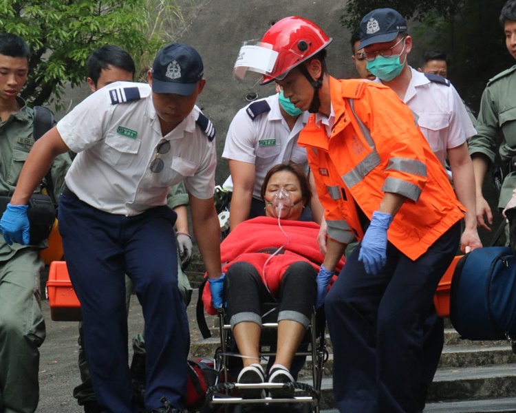 救護員將傷者抬下山送院。歐陽偉光攝