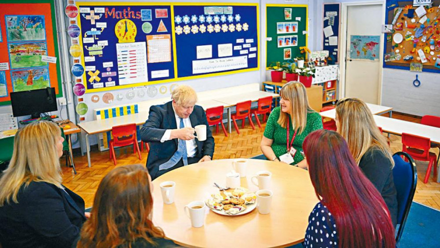 英國教師將獲加薪百分五。圖為首相約翰遜與幼兒園教師茶敍。