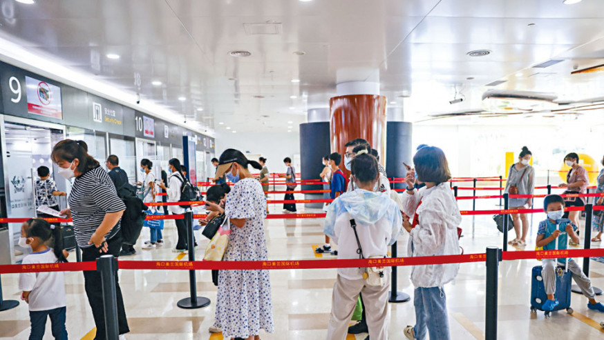返程旅客在海口美蘭機場候機樓內準備接受安檢。