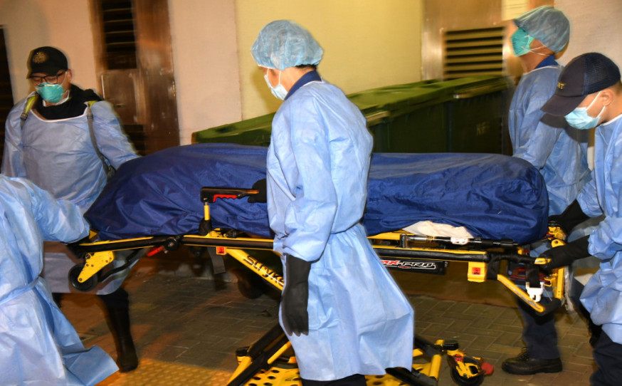 仵工將女死者屍體舁送殮房。李家傑攝