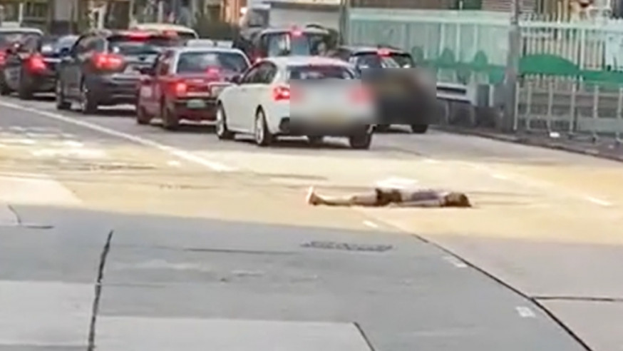 一名女子臥在荔枝角道馬路中間，險象環生。影片截圖