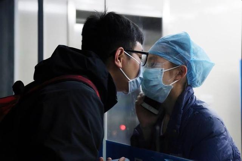 疫情之下的愛情有多浪漫,護士時隔11天隔著玻璃口罩與男友親吻成經典。(網圖)