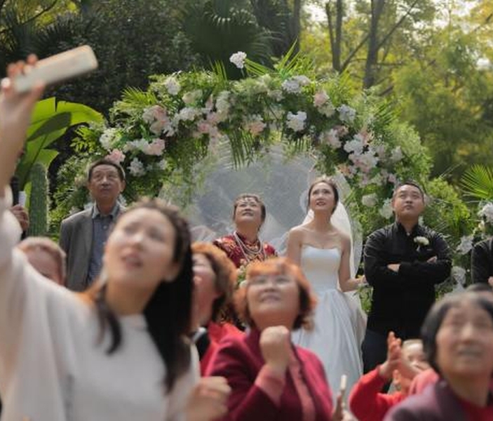 四川一對新人的婚禮上,有直升機在空中撒利是及鮮花,賓客看得目瞪口呆。(網圖)